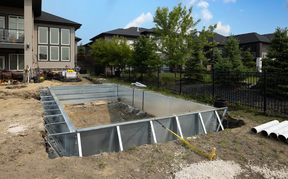 Ground-level view of a 14’ x 28’ steel pool kit in construction